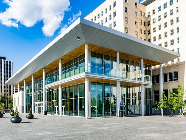 Modern visitor centre with glass façade and plaza at Alberta Legislature.