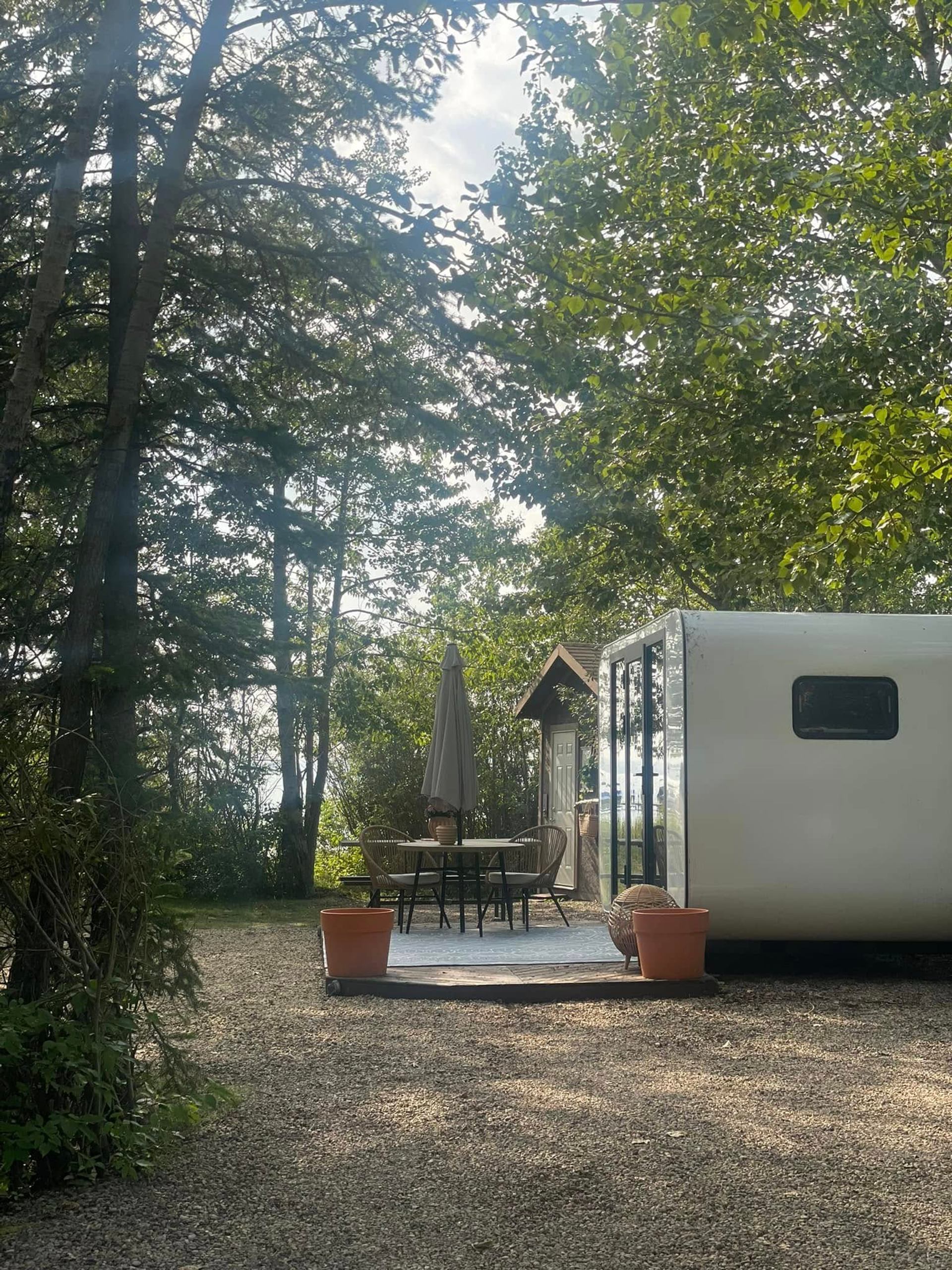 A cabin patio with table and chairs sits among trees at Wilson’s Beach Campground.