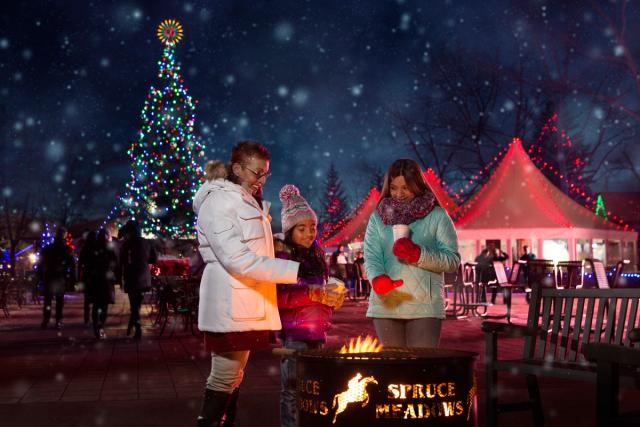 Family standing around a fire pit at the Spruce Meadows International Christmas Market