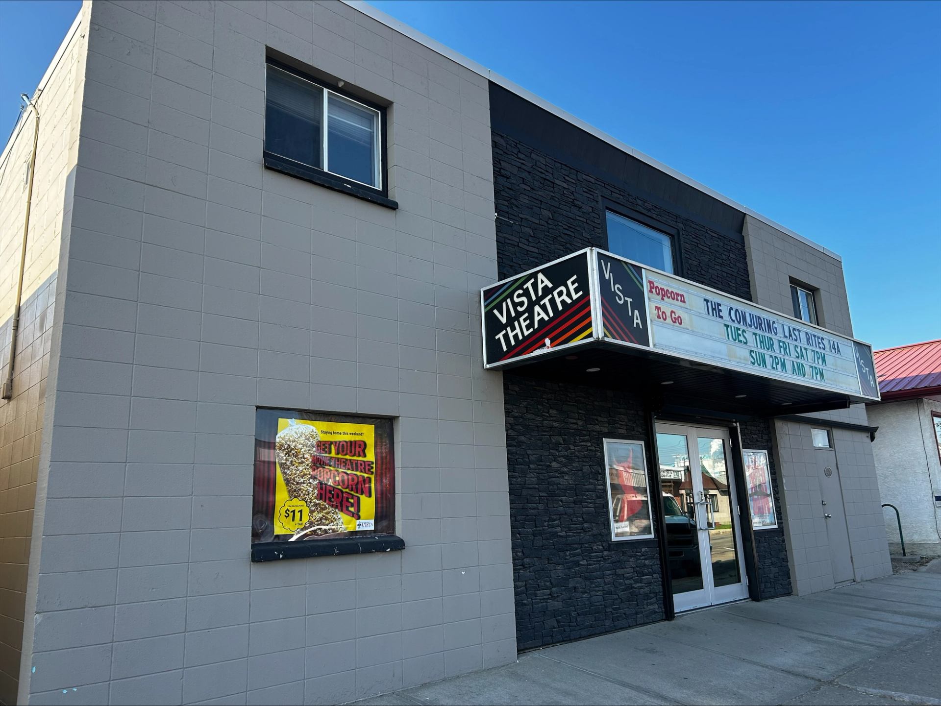 Small theater with marquee and movie posters.