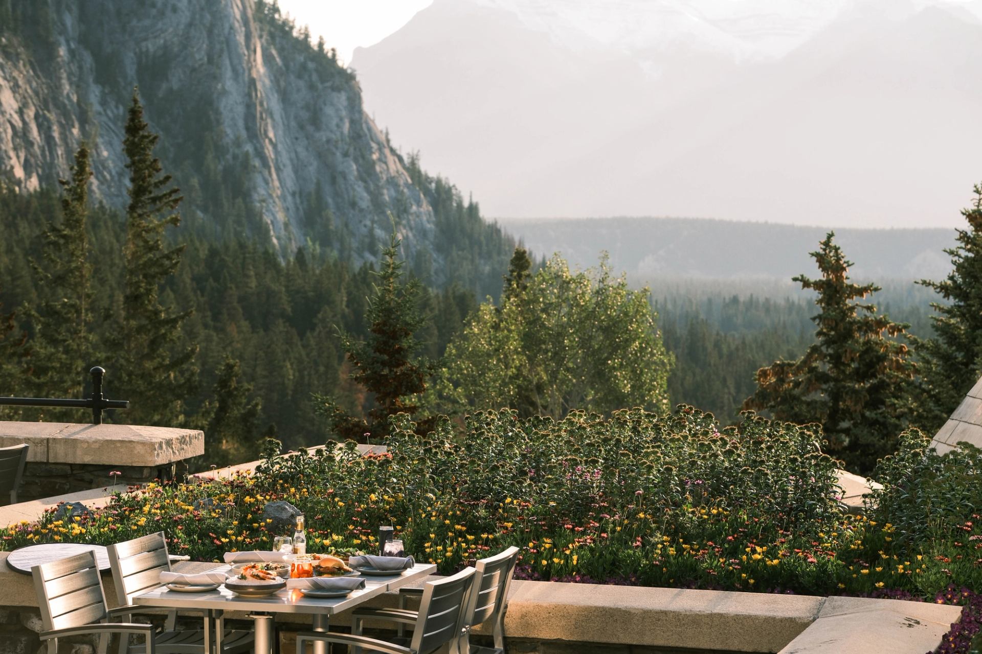 Outdoor dining table on The Rundle Patio with mountain views and lush greenery.