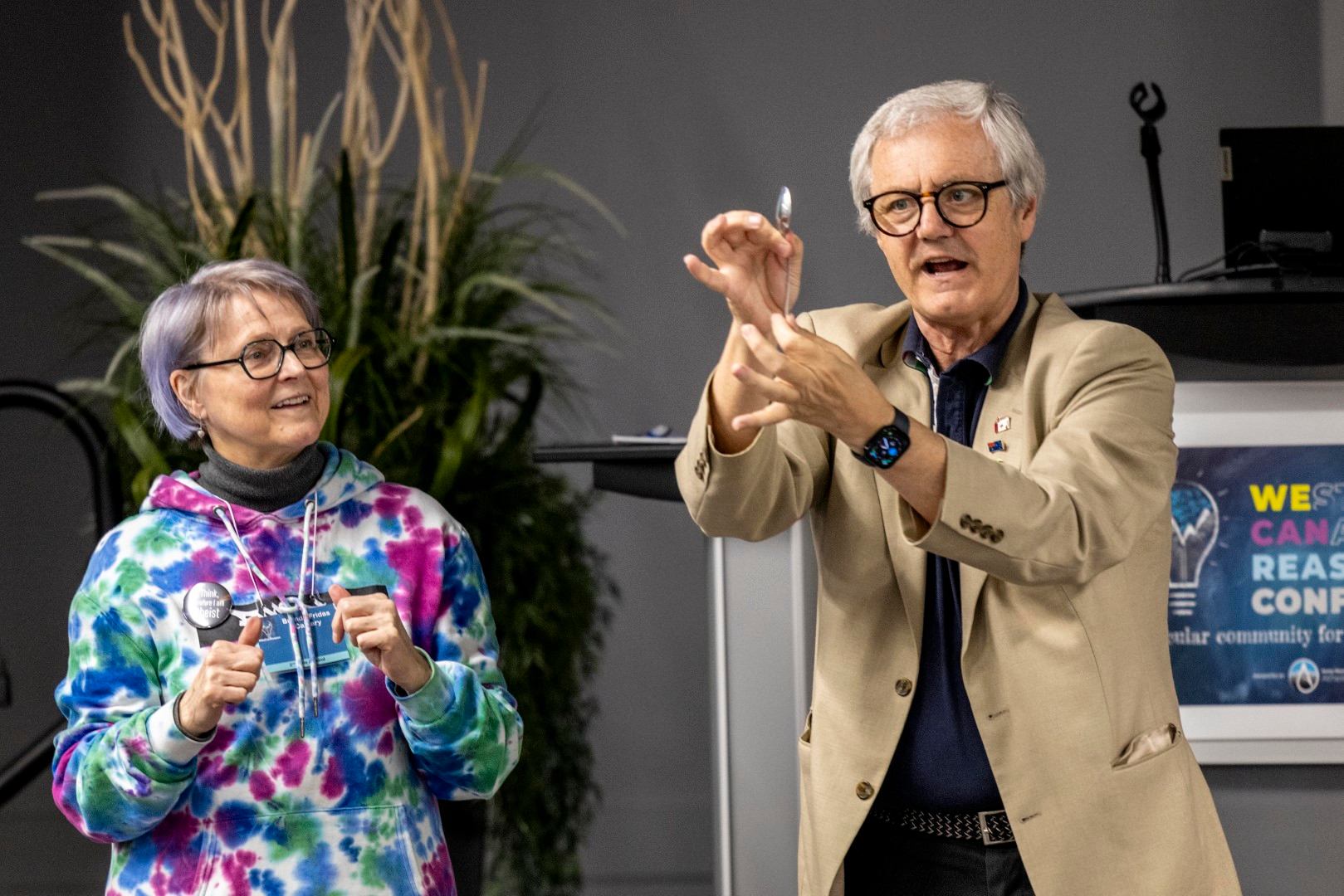 Speakers at the Western Canadian Reason (WeCanReason) Conference, one pointing at an audience.