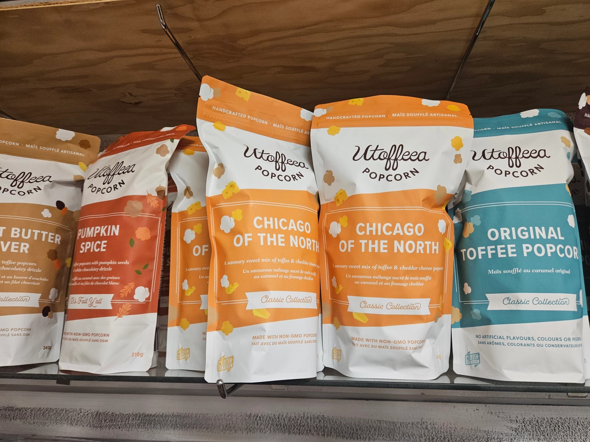 Shelf of Wilderness Popcorn bags in assorted flavors like Pumpkin Spice and Toffee.