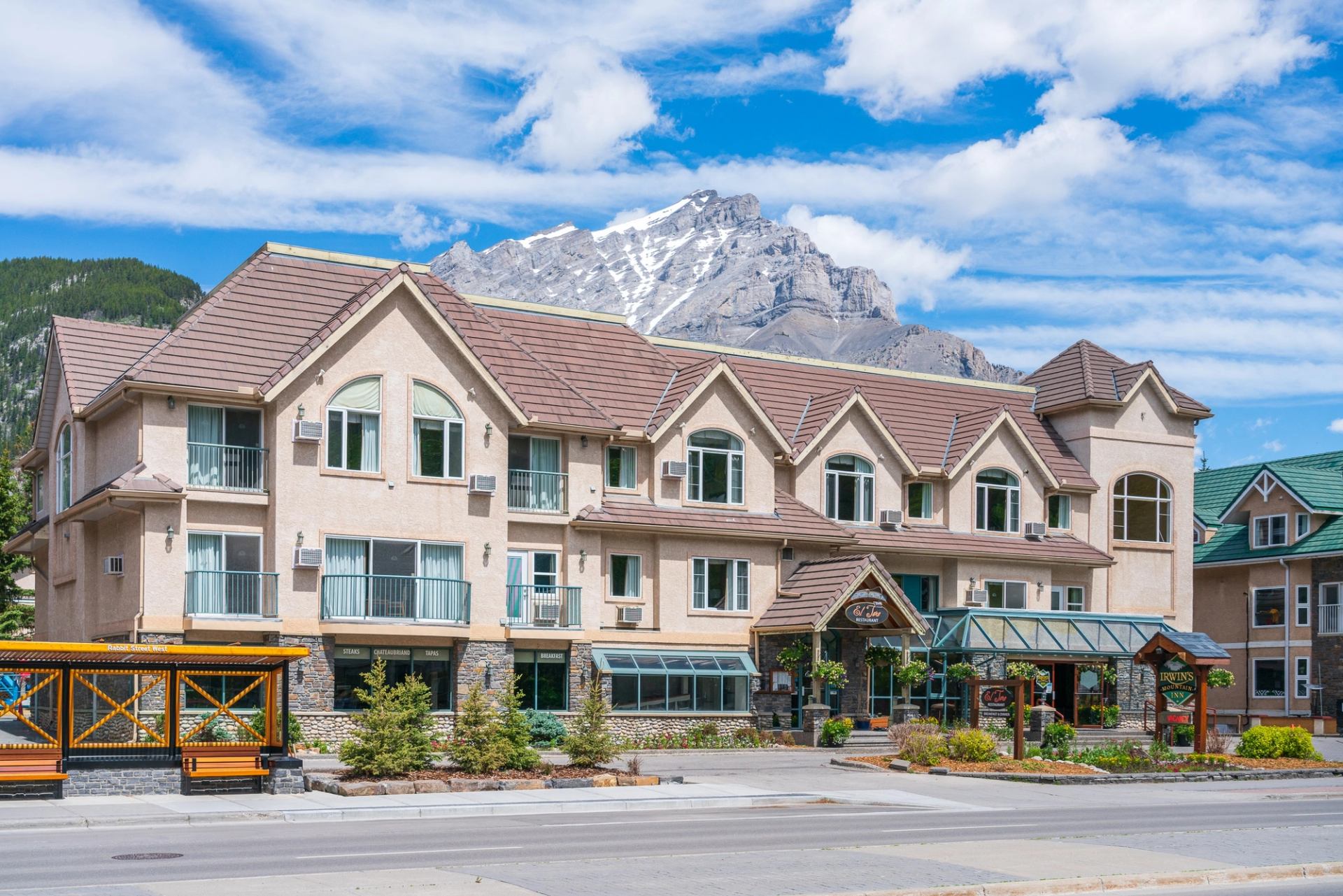 Irwin's Mountain Inn with scenic mountains and clear blue sky.