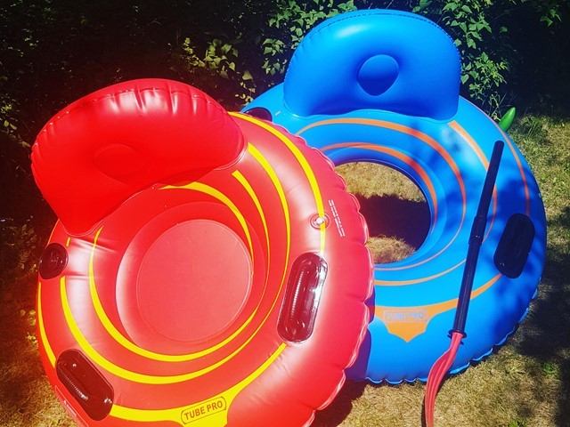 Two colorful inflatable water tubes with paddle, ready for river adventure.