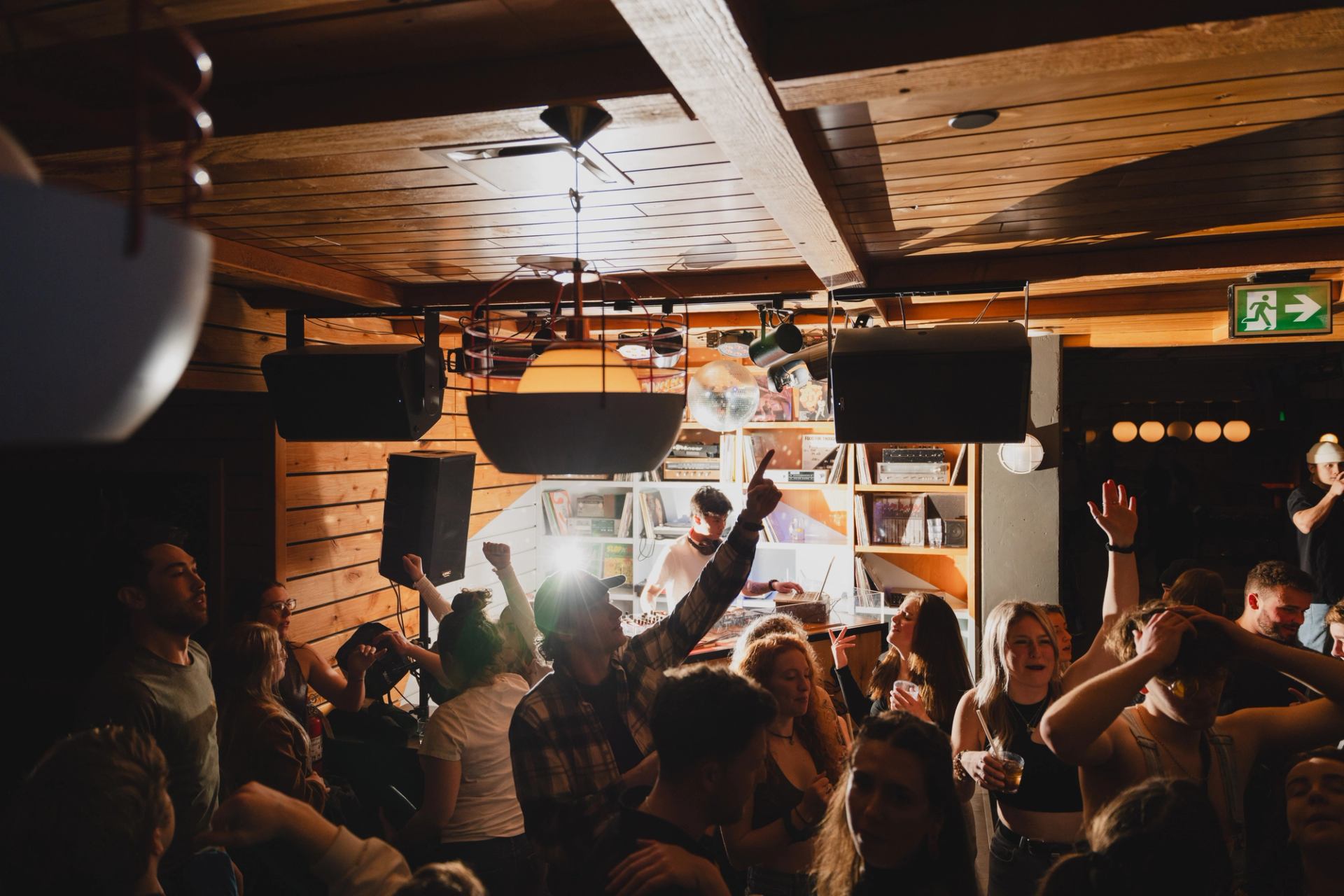 A crowded dance floor in front of DJ booth. 