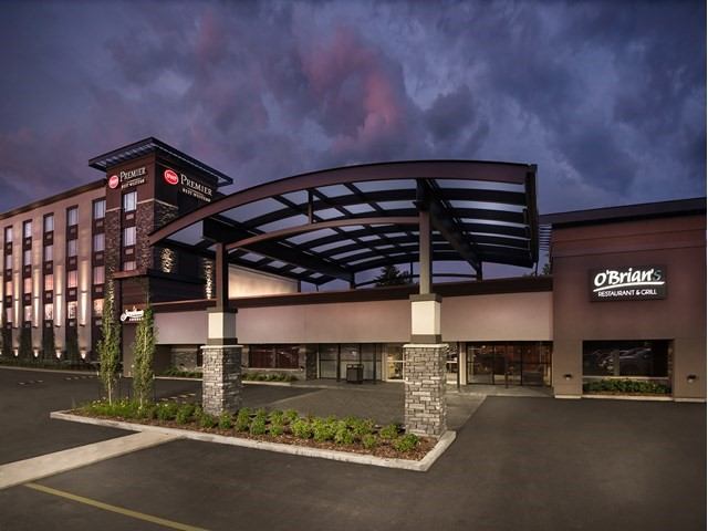 Stylish hotel with covered entrance under a dramatic evening sky.