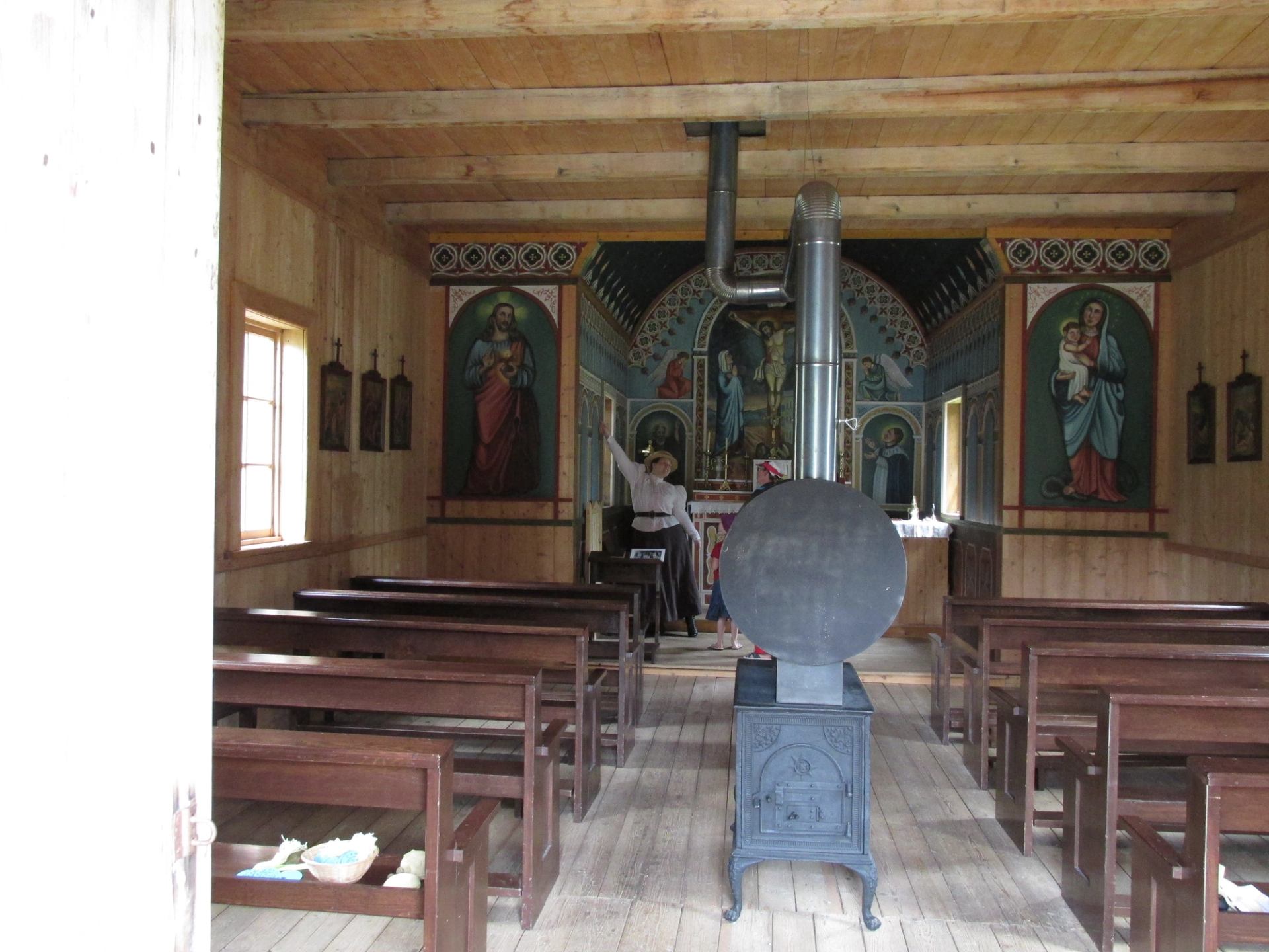 Interior of a historic chapel with wooden pews and painted icons at Historic Dunvegan.