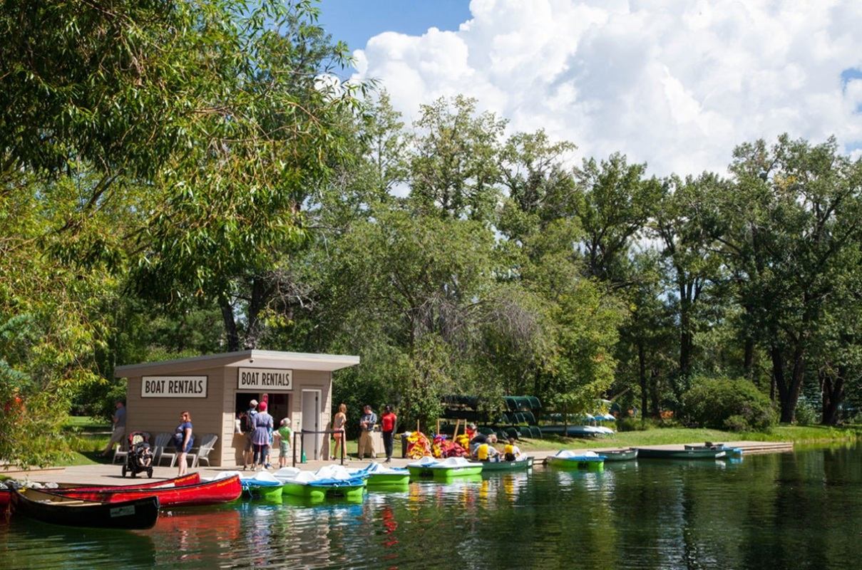 Visitors renting boats by the water at Bowness Park