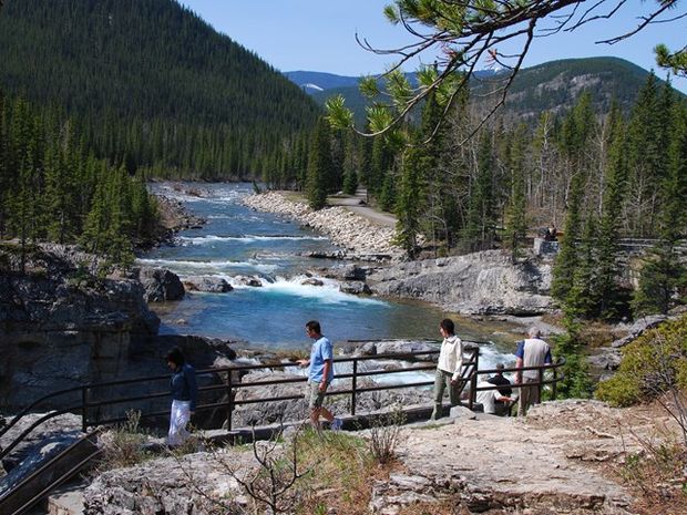 People walking on Trail looking out at Elbow Falls.