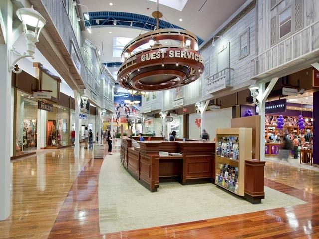 Mall interior with guest services desk and stores on both sides.