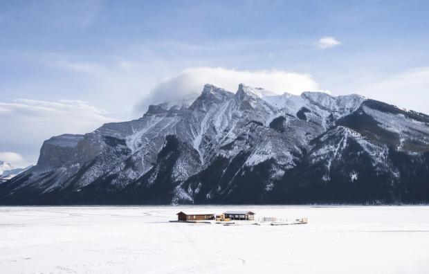 An ice fishing lodge set up on the middle of a frozen Lake Minnewanka in Banff National Park.