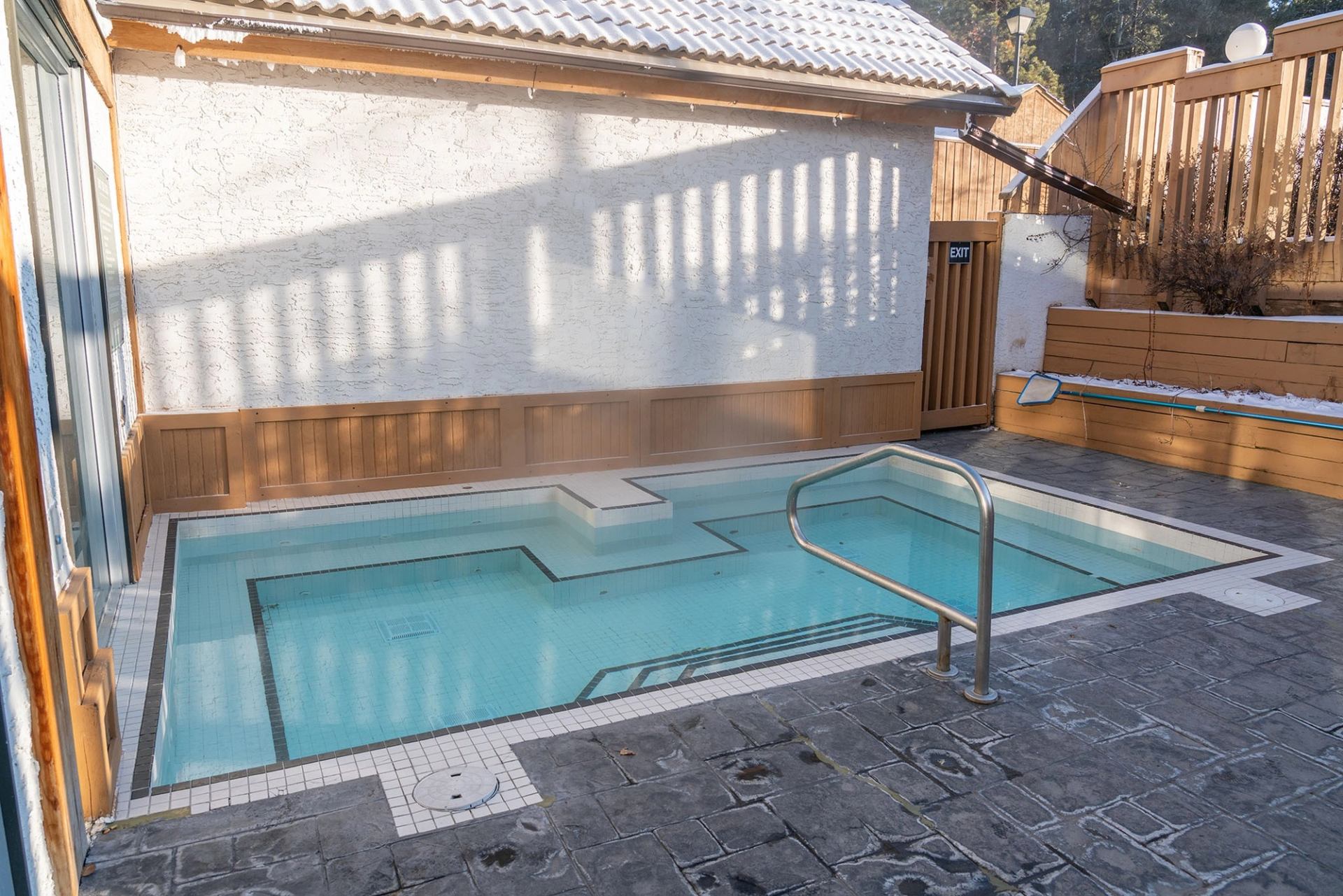 Outdoor hot pool with snowy surroundings at Banff Rocky Mountain Resort.