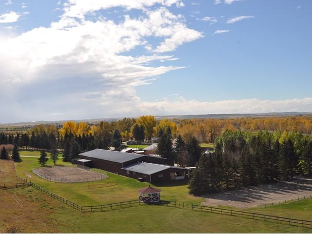 Aerial view of Lynnwood Ranch with fall trees, buildings, and open grassy areas.
