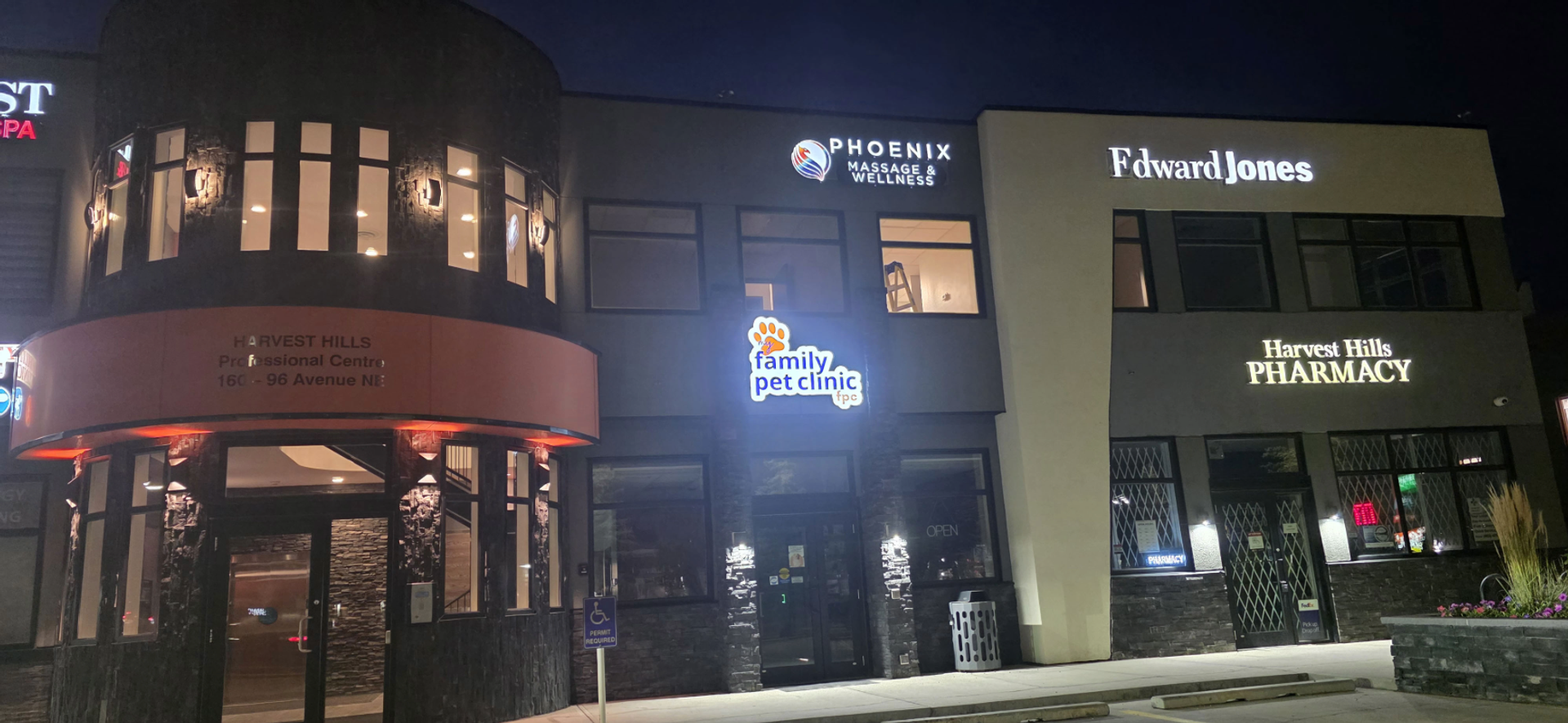 Illuminated storefronts include Family Pet Clinic, Edward Jones and Harvest Hills Pharmacy.