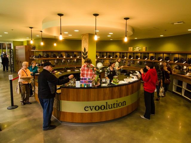 evoolution Enjoy Centre reception desk with shoppers and bar shelves in the background.