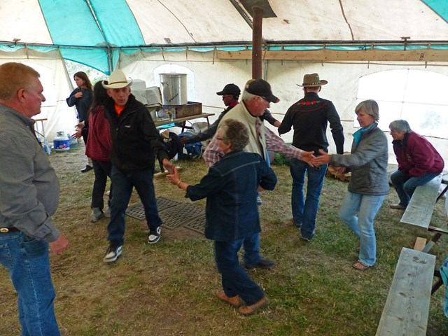 A group of people dance under a large tent.