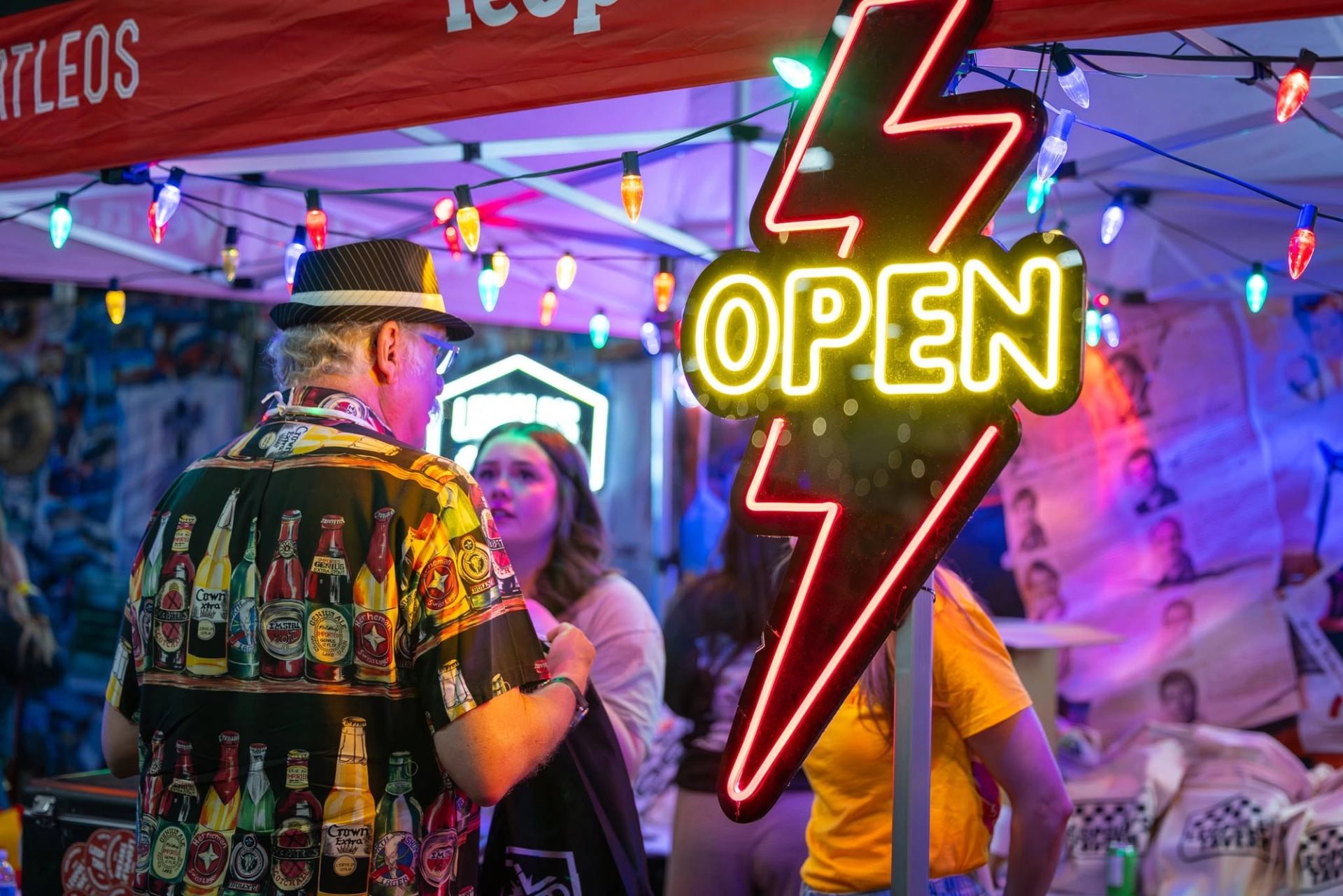 Vendor booth with lots of lights and Open sign