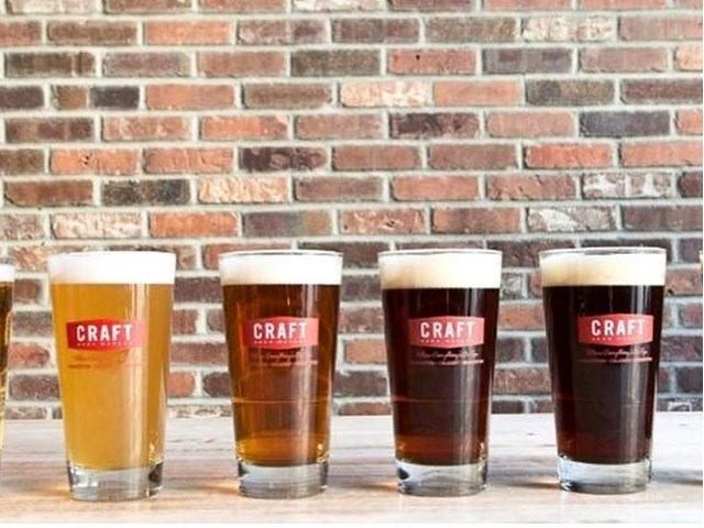 Four pints of craft beer from light to dark in a row at CRAFT Beer Market.