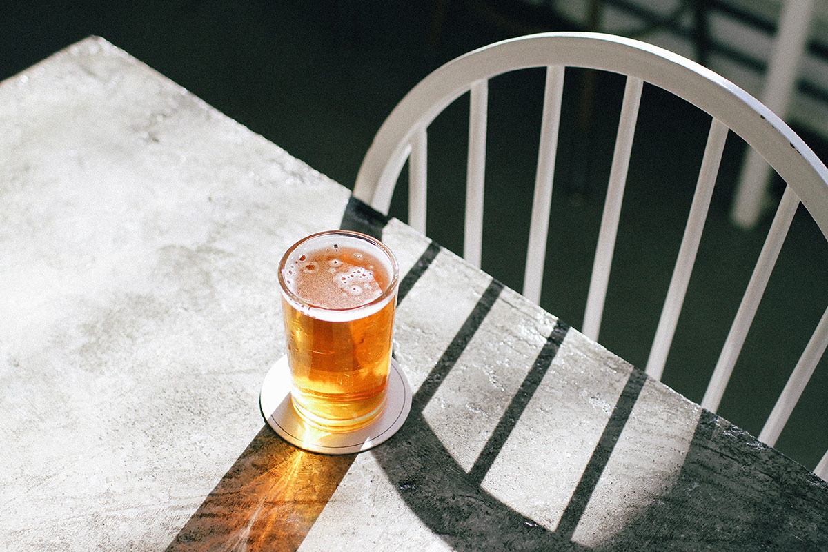 A 33 Acres Brew on a table with sunlight shining on it.