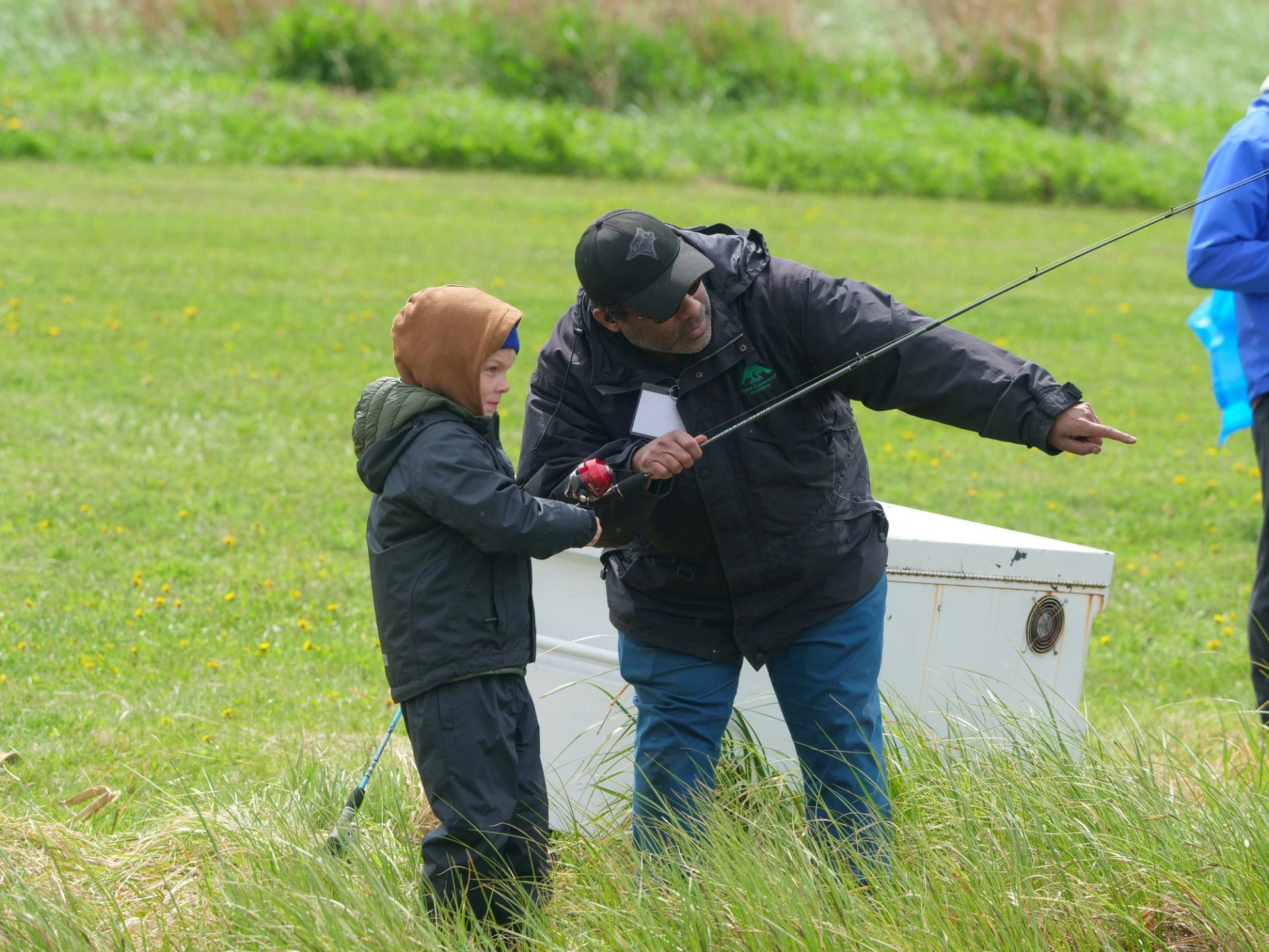 A young angler learning to fish with mentor.