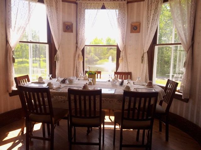 Elegant dining room with lace tablecloth and garden view at Cronquist House.