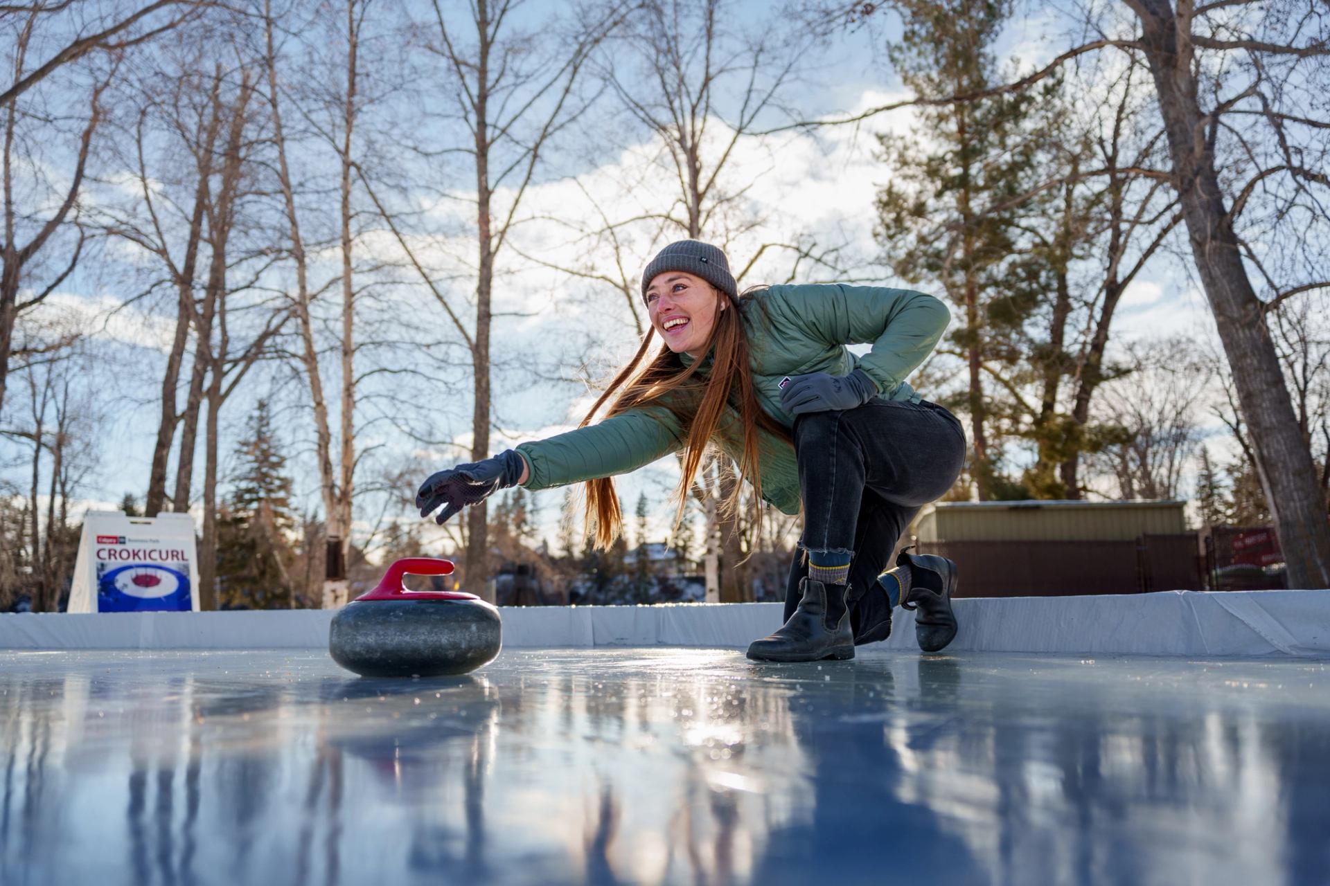 A young women is playing Crokicurl at BownessPark in Calgary on a sunny winter day