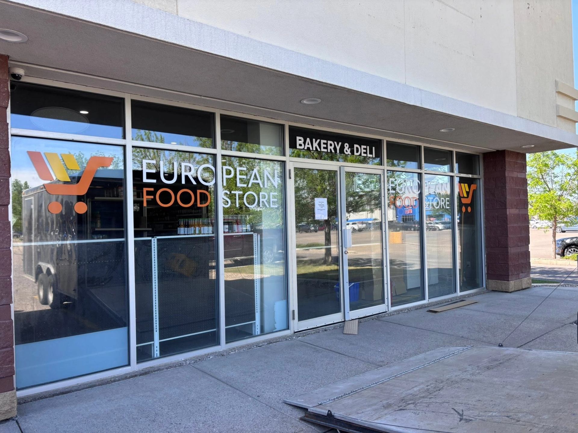 Storefront of Wooden Shoe European Food Store with bakery and deli signage above glass doors.