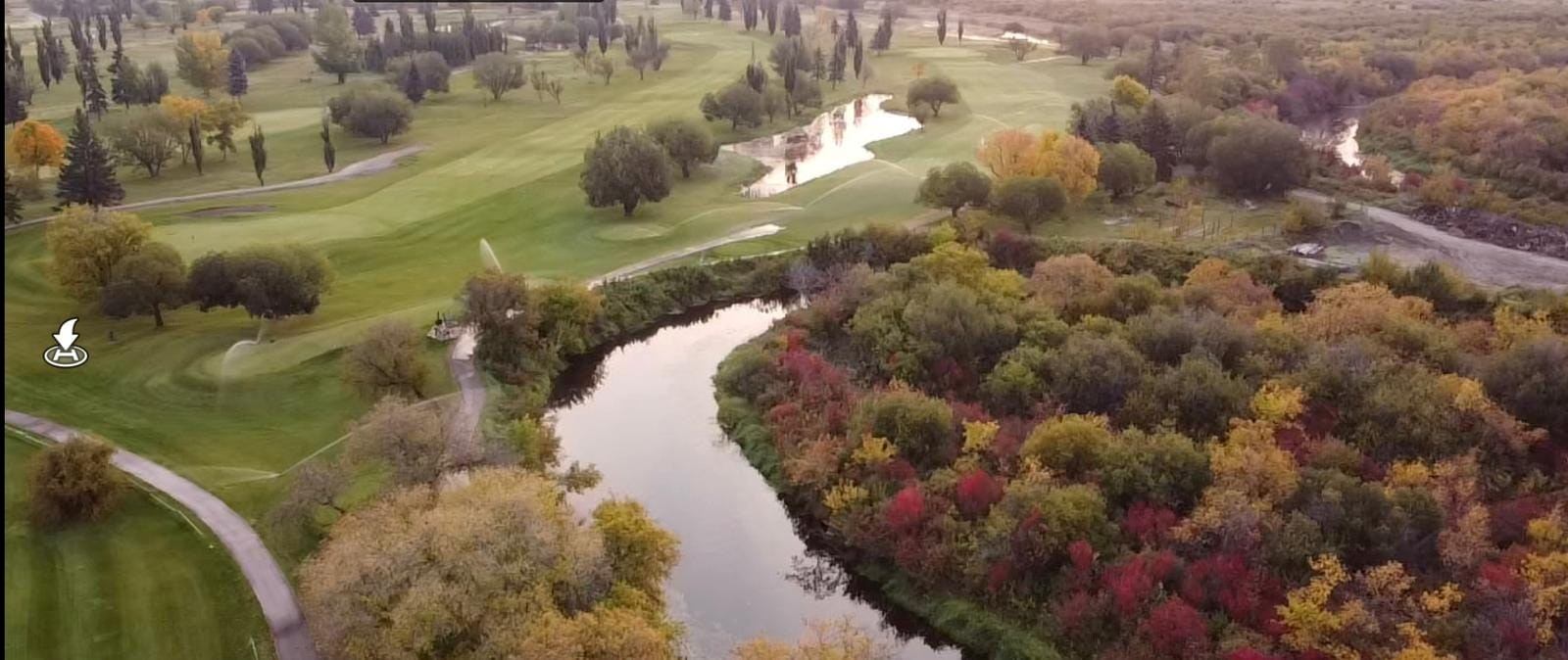 Scenic aerial shot of golf course with ponds and colorful autumn trees