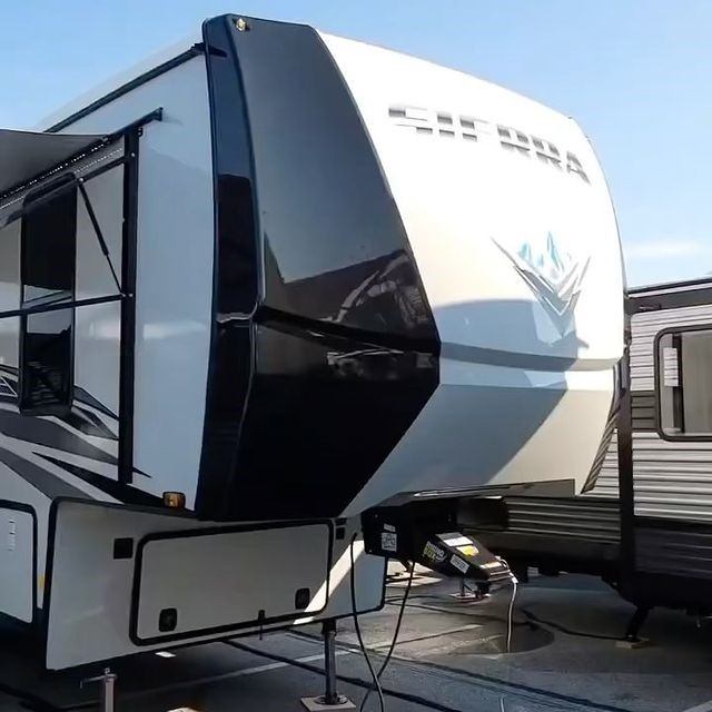 Sierra fifth-wheel trailer parked outdoors with logo visible on front cap.