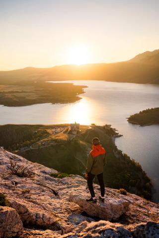 Hiker enjoying sunrise from Bear's Hump above Waterton.