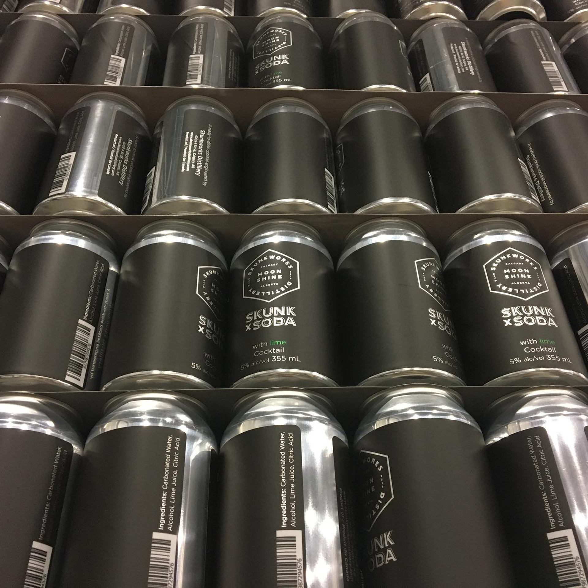 Cardboard trays filled with black Skunk x Soda cocktail cans labelled 355 mL, 5% alc.