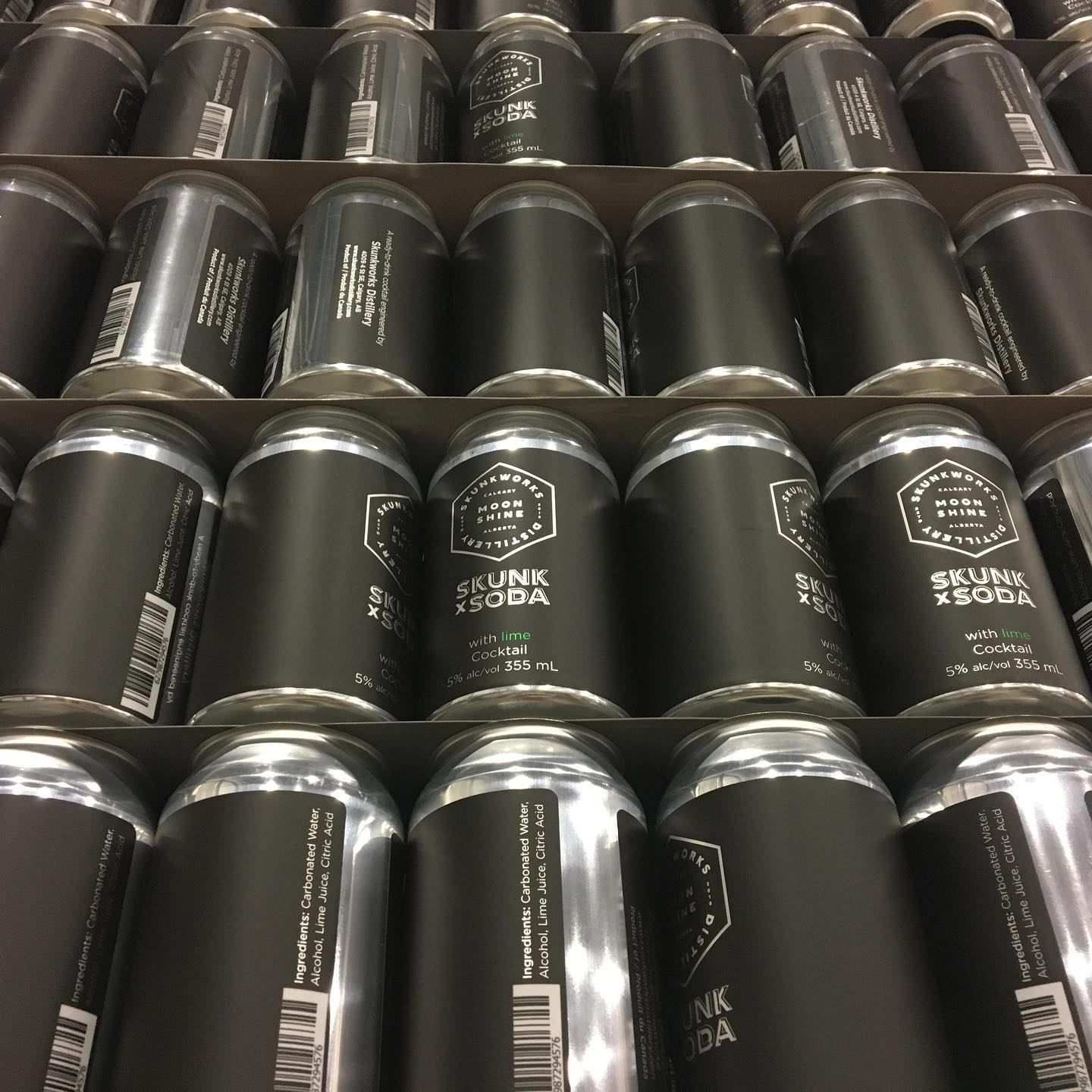 Cardboard trays filled with black Skunk x Soda cocktail cans labelled 355 mL, 5% alc.