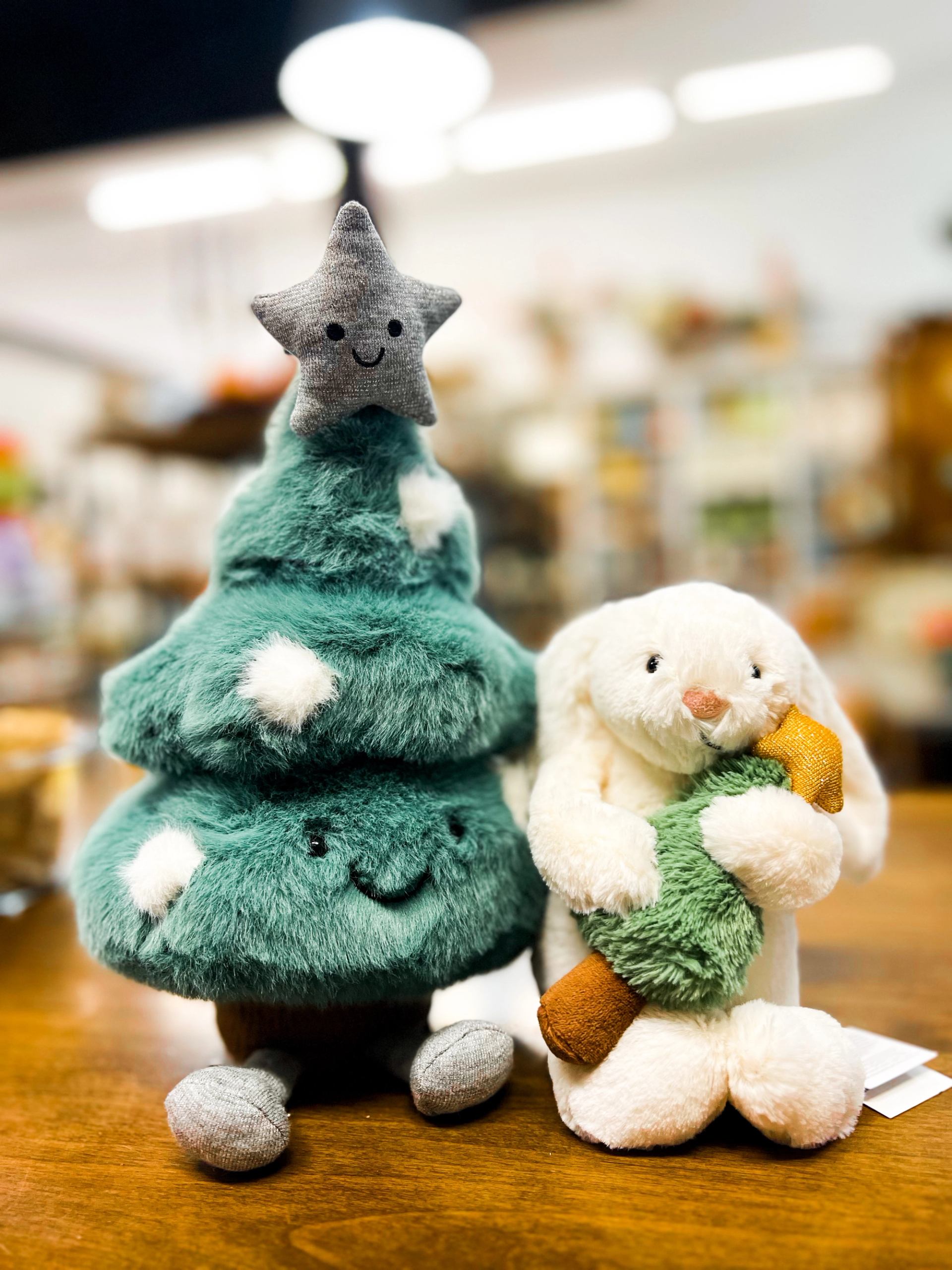 Plush star doll and rabbit stuffed toys on a wooden shelf in a store.