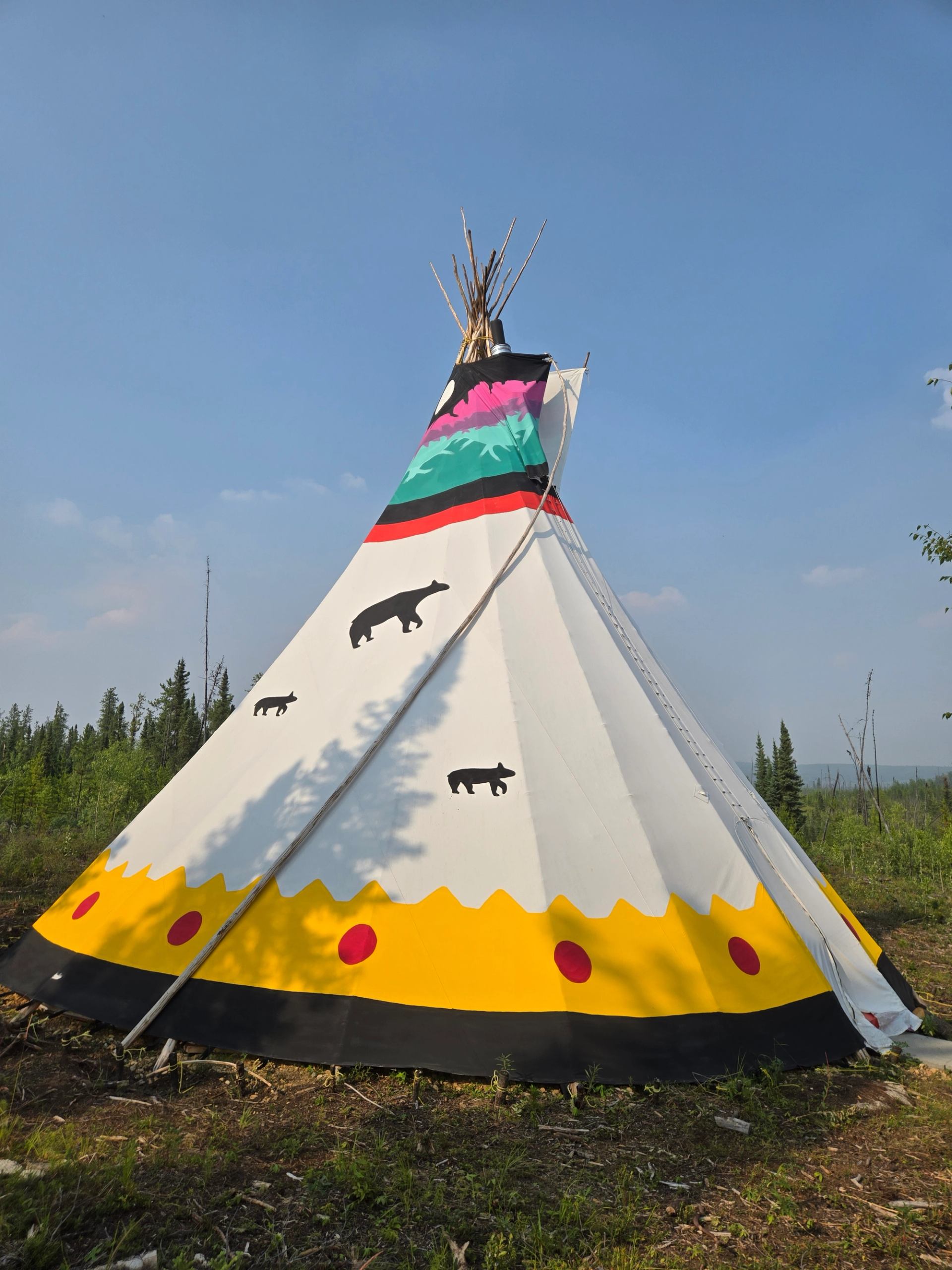 Large teepee painted with aurora designs on top mama bear and cubs and yellow and red on bottom 