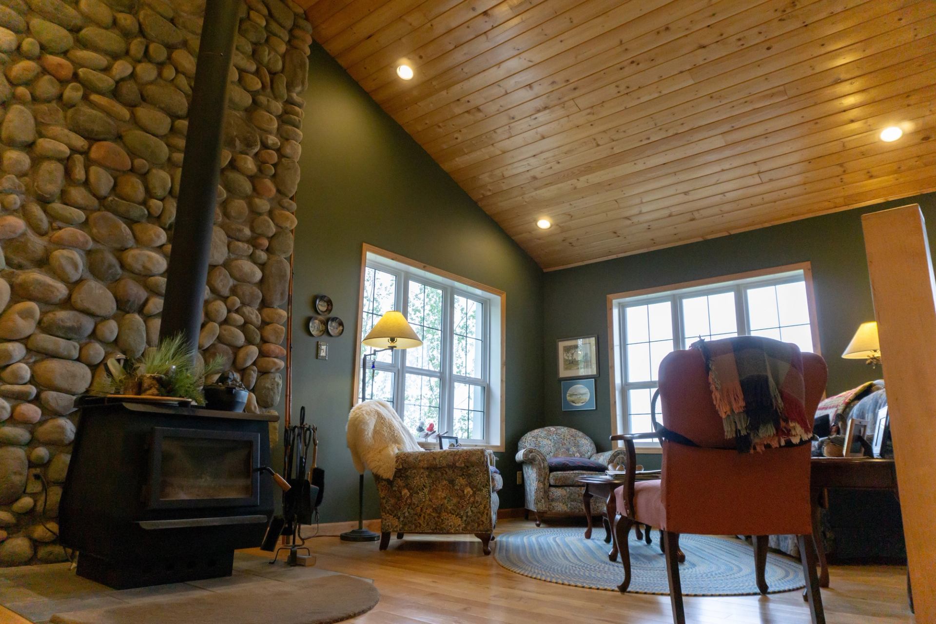 Cozy living room with stone fireplace and wood ceiling.