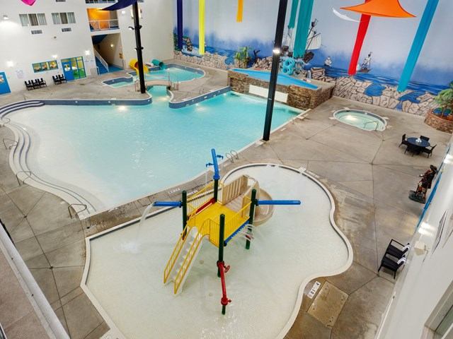 Indoor pool area with splash zone and hot tub at Holiday Inn.