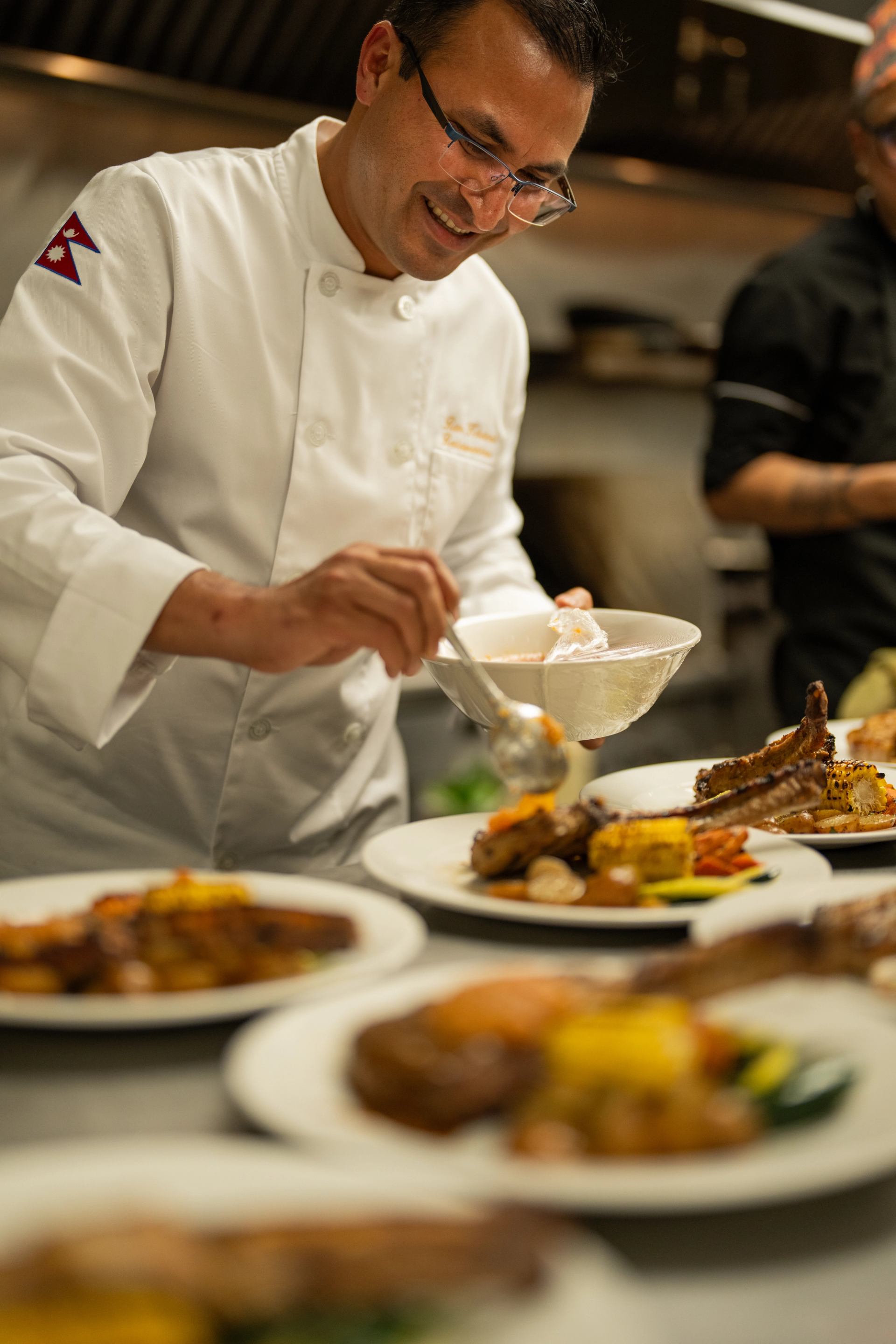 Chef plating gourmet dishes in a professional kitchen at Cattleman’s Chophouse.