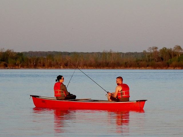 Two people fishing on the lake in a boat
