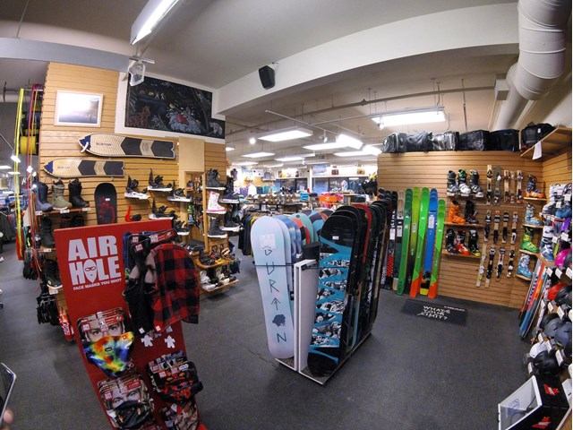 Ski and snowboard gear neatly arranged in a mountain sports shop.