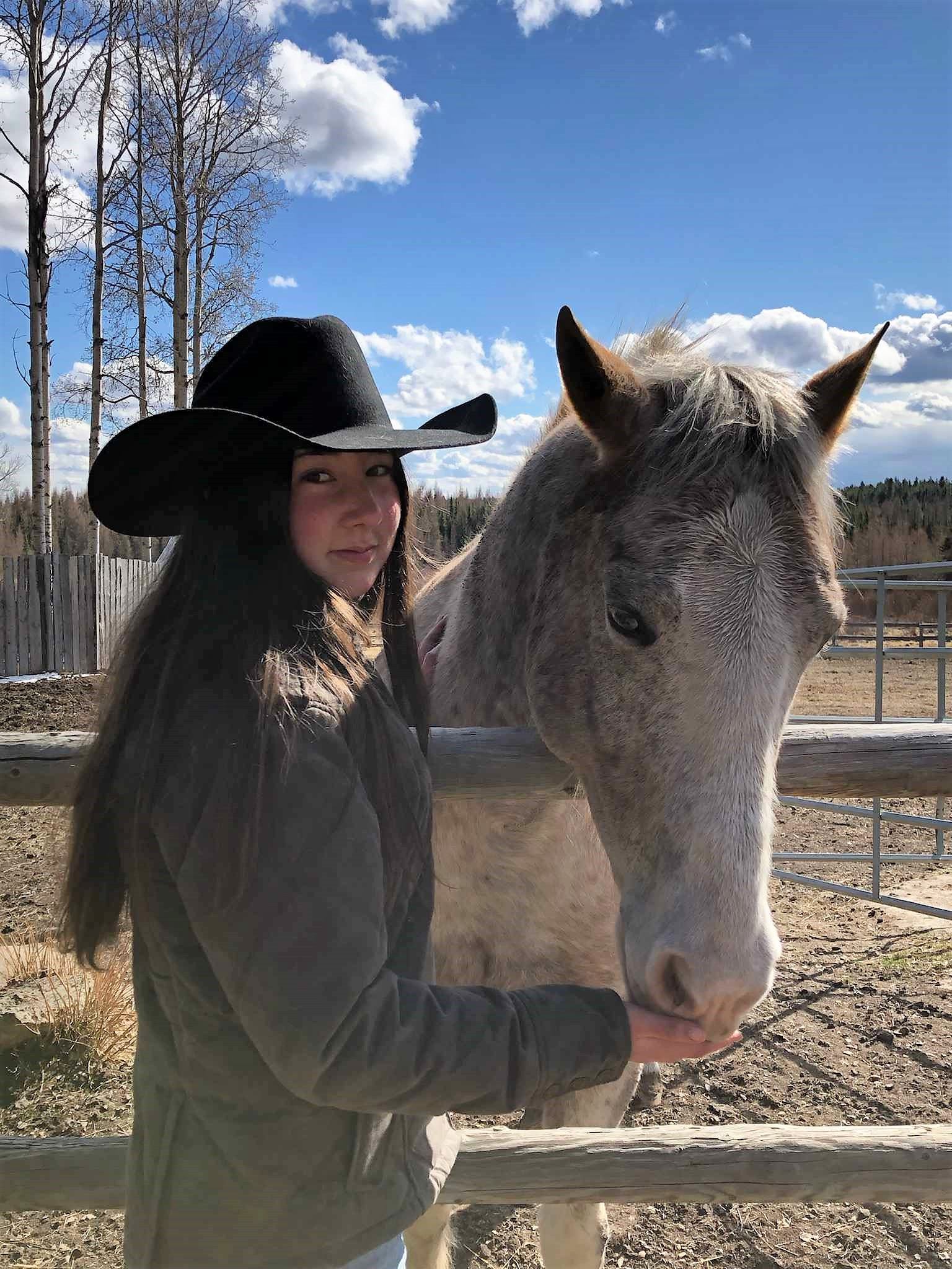 A girl feeding her horse