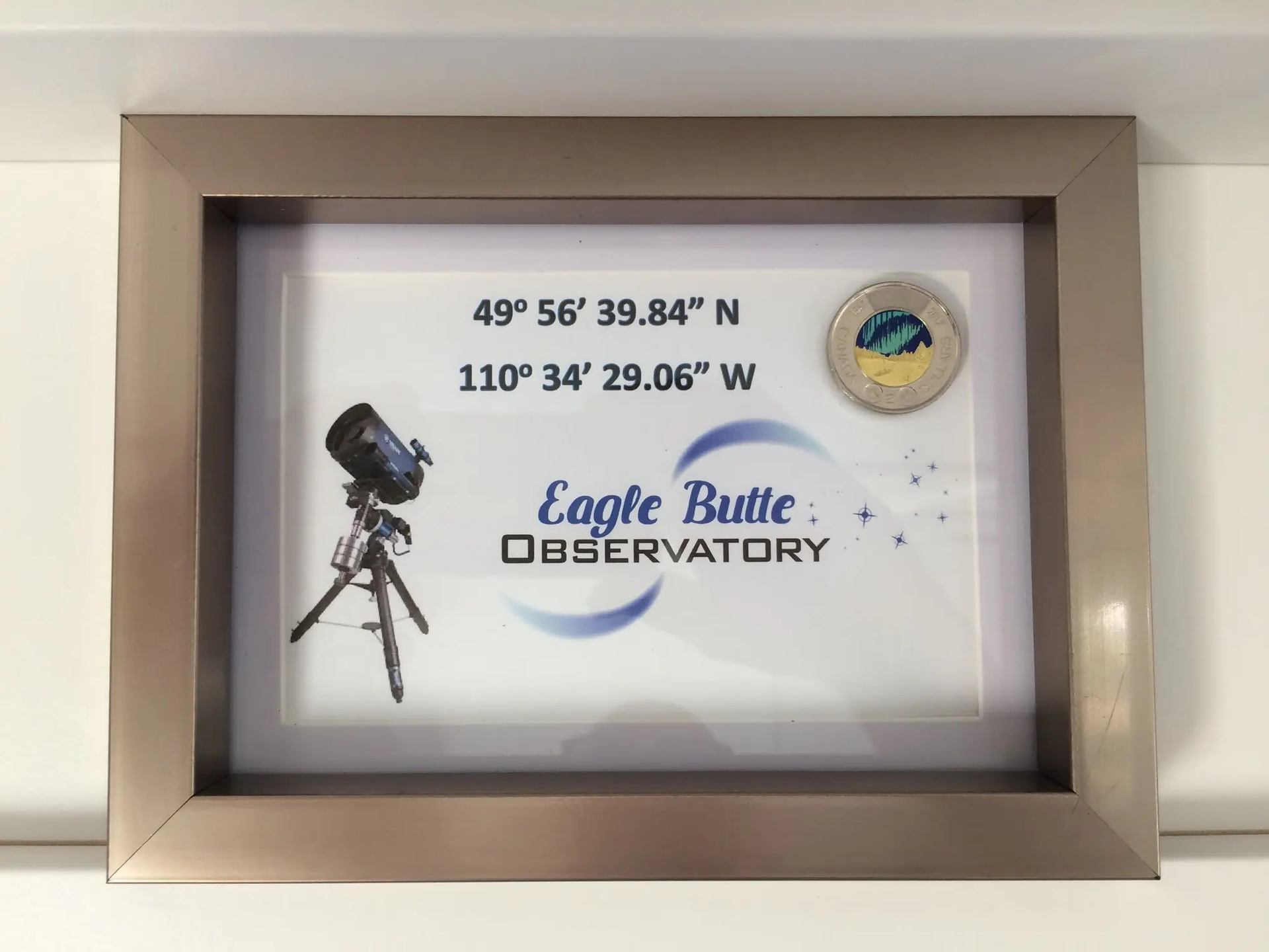 Framed Eagle Butte Observatory sign with coordinates and telescope illustration.
