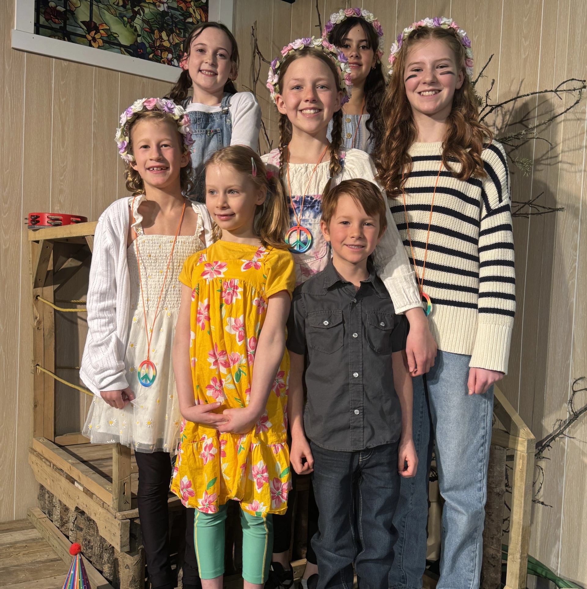 Kids in bright costumes and flower crowns on stage.