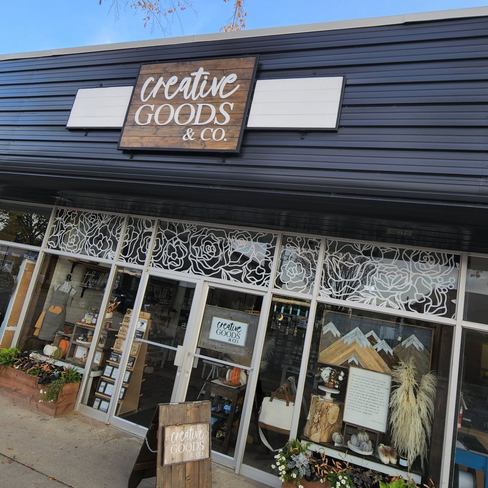 Creative Goods & Co. shop with black facade, white signage, and decorative window art.