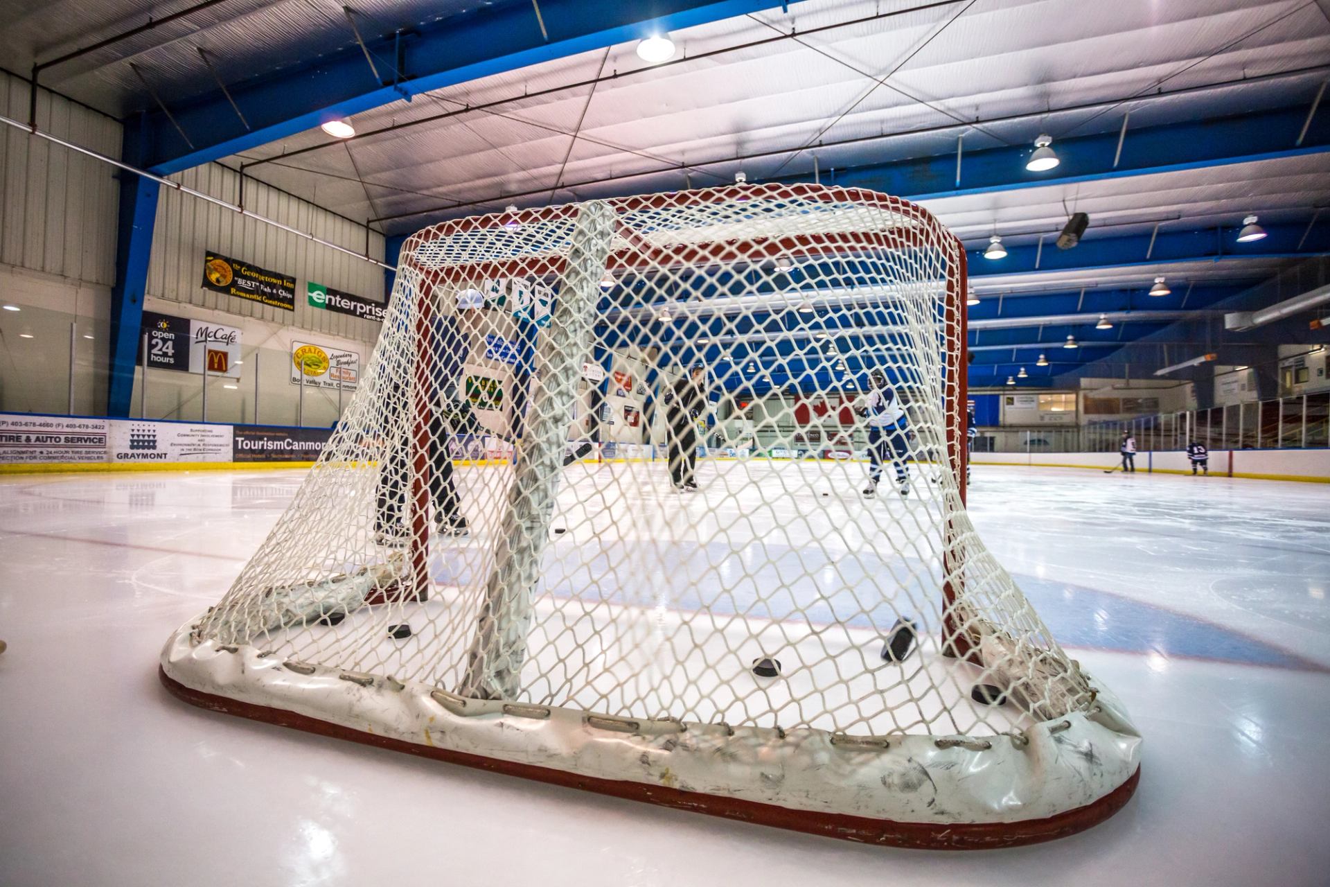 Hockey goal net with scattered pucks on indoor rink during Viking Cup.