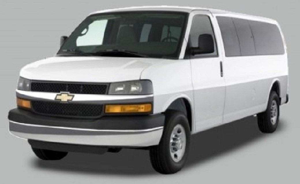 A white shuttle van with tinted windows.