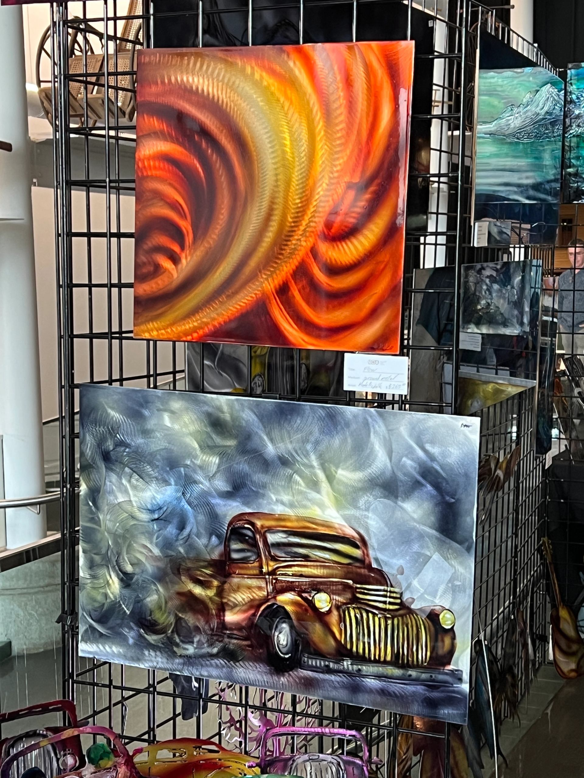 Metal paintings featuring swirling colors and a stylized truck design.
