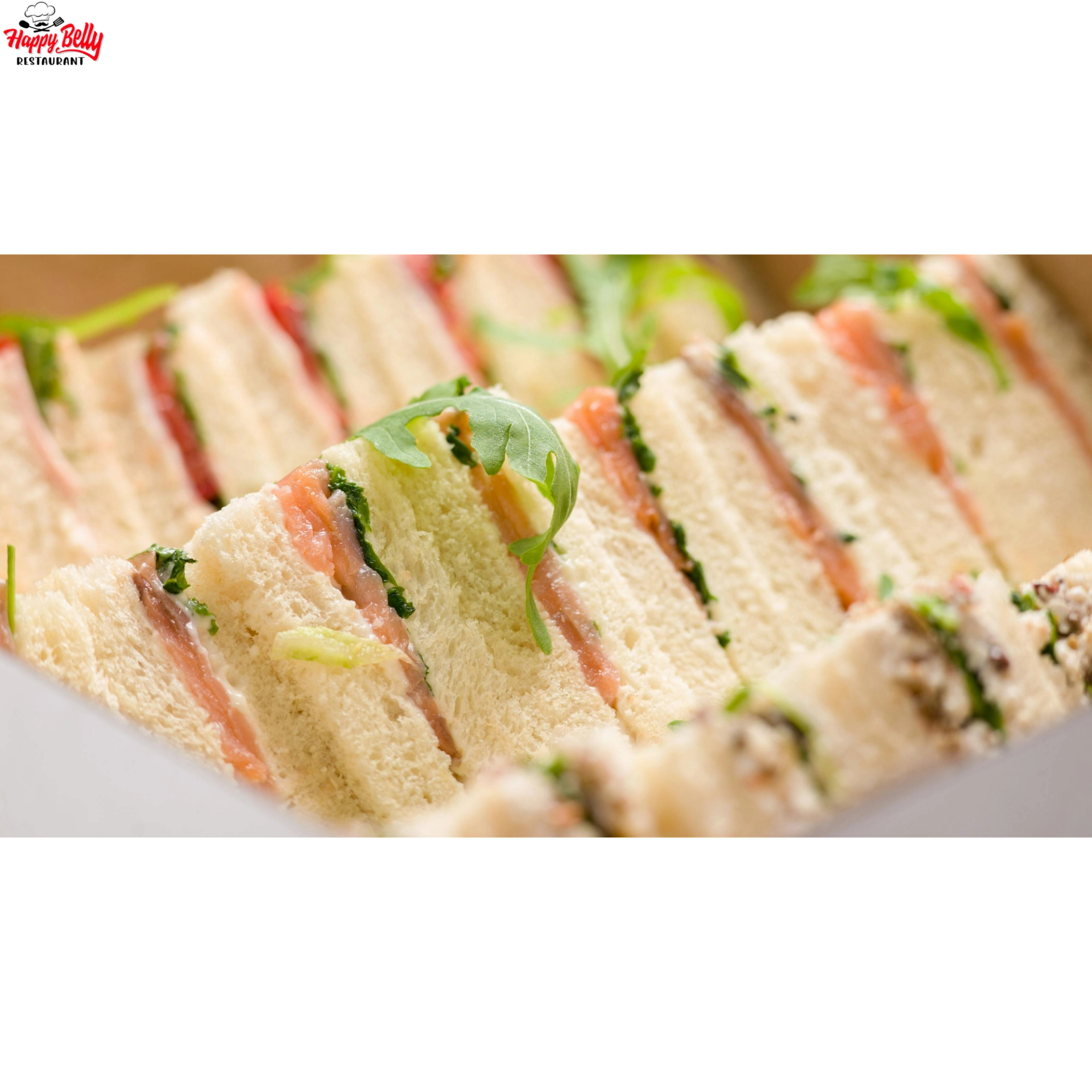Stacked finger sandwiches with salmon, greens and white bread, garnished with arugula.