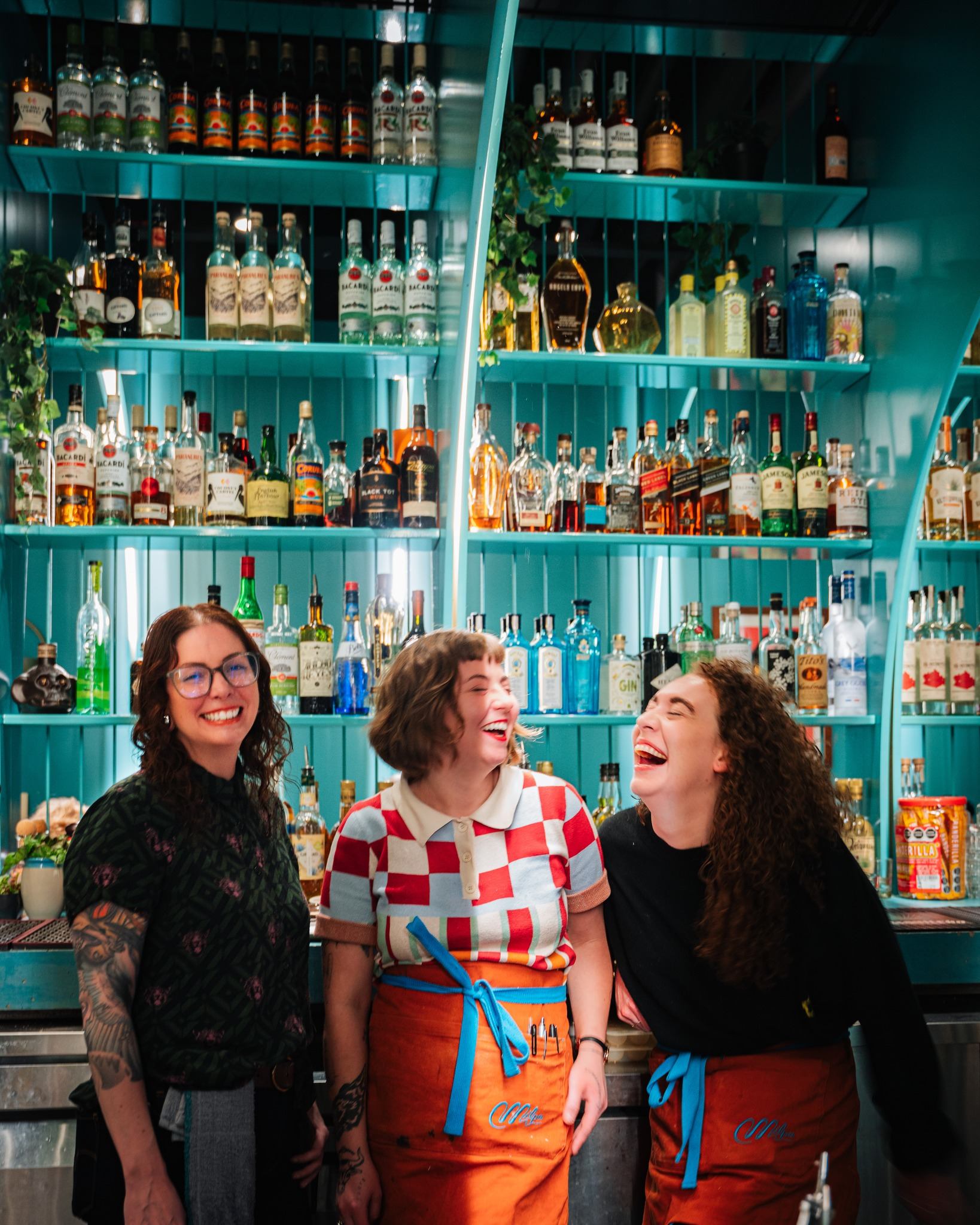 Three of their incredible team sharing laughter at the bar.