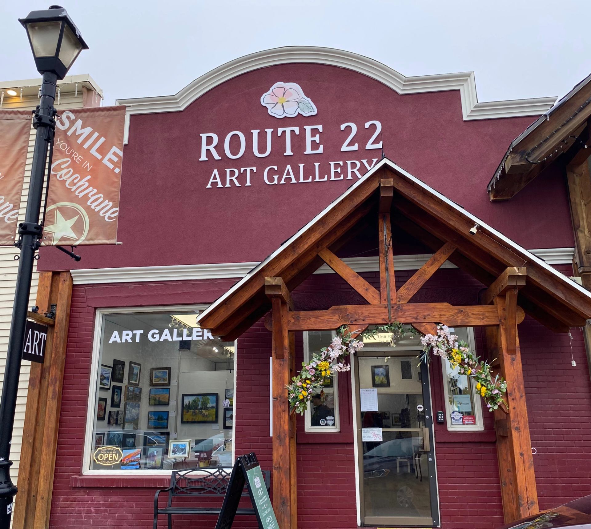 Route 22 Art Gallery storefront with red façade, timber entrance and floral arch.